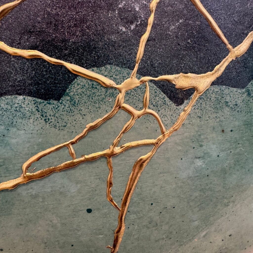 Close-up van een groen en zwart kommetje met een web van gouden Kintsugi-lijnen